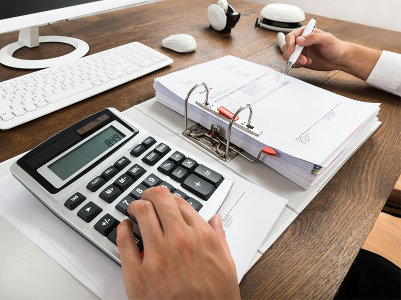 Businessman Checking Invoice With Calculator