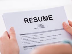Cropped image of young woman holding resume over white