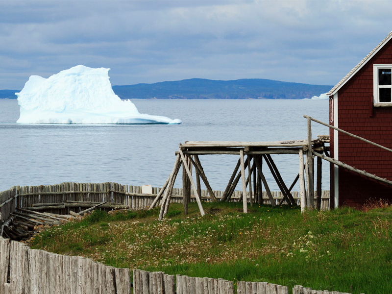 An iceberg gounded near an old fishing stage