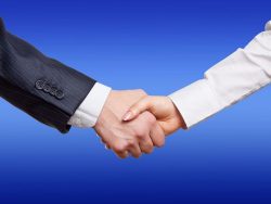 man woman handshake by close up on a blue background