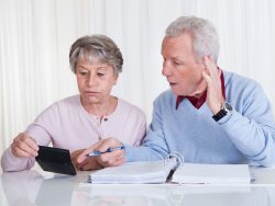 stressed senior couple calculating budget at home