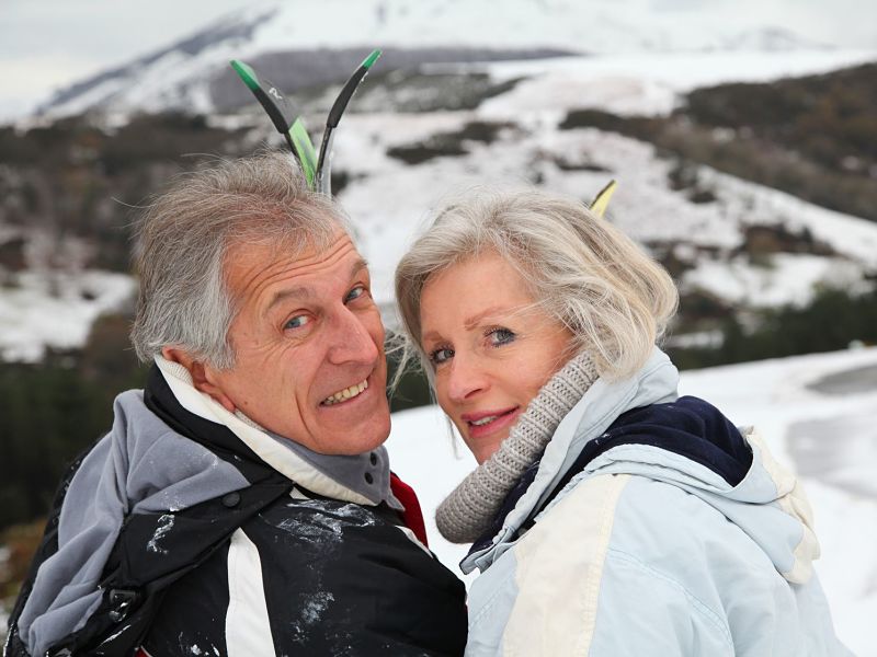 Senior couple with skis, mountain backgroung