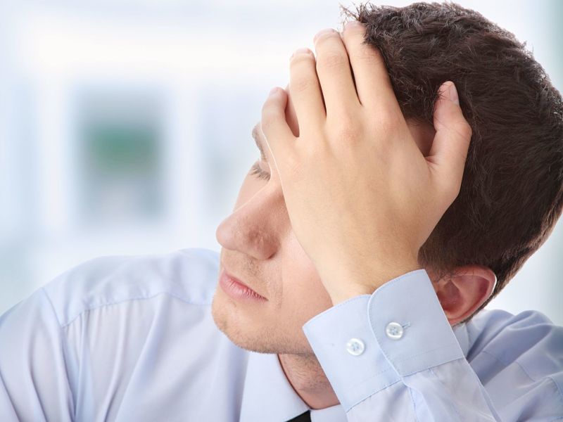 businessman in depression with hand on forehead
