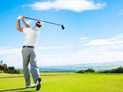 man playing golf on beautiful sunny green golf course