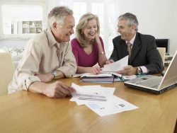 senior couple sitting at table with financial advisor