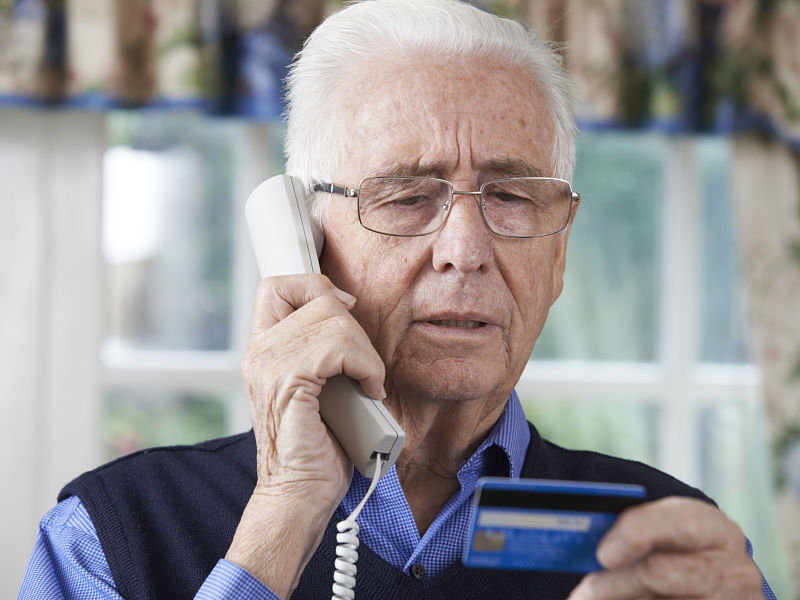 senior man giving credit card details on the phone