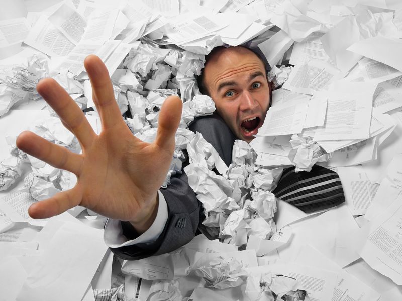 businessman sinking in heap of documents