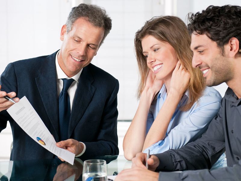 happy young couple discussing with a financial agent