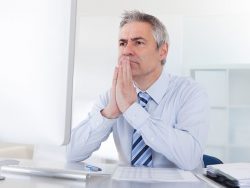 mature businessman thinking at desk in office