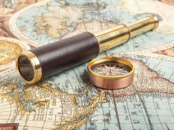 vintage brass telescope on old antique map