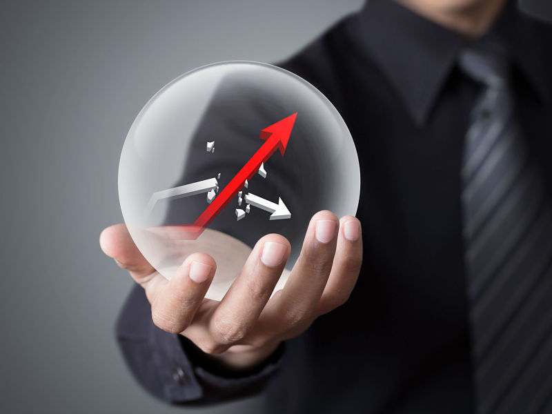 businessman holds crystal ball with rising red graph and broken white graph