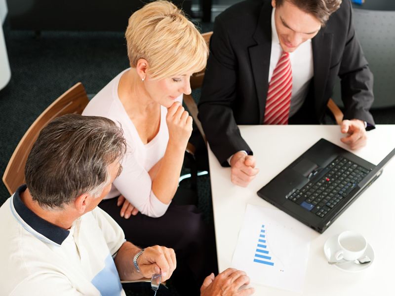 mature couple with young financial advisor