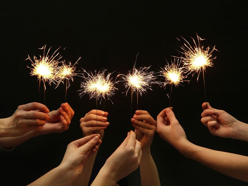 beautiful sparklers in hands on black background