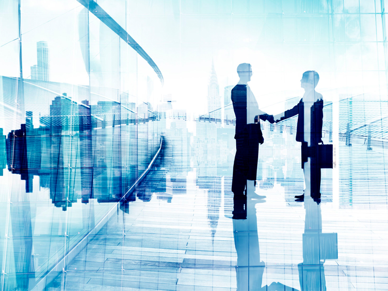 two businesspeople shaking hands in silhouette