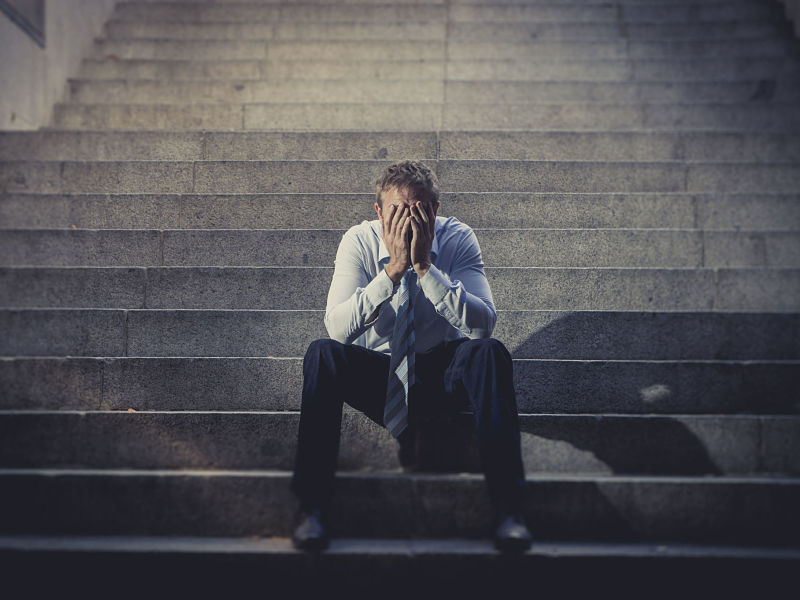 Depression, business man sitting on ground street concrete stairs suffering emotional pain,