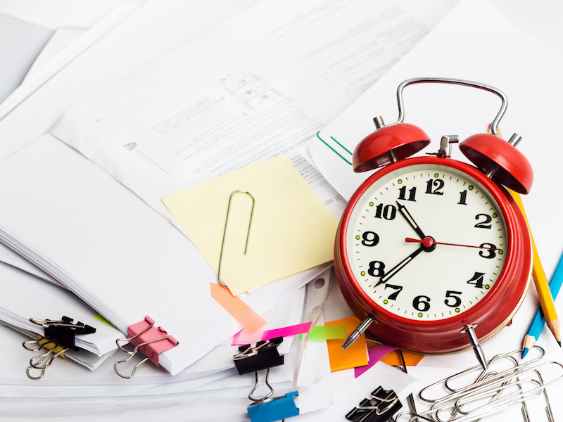 Time management concept. Composition with documents, stationary and alarm clock on table