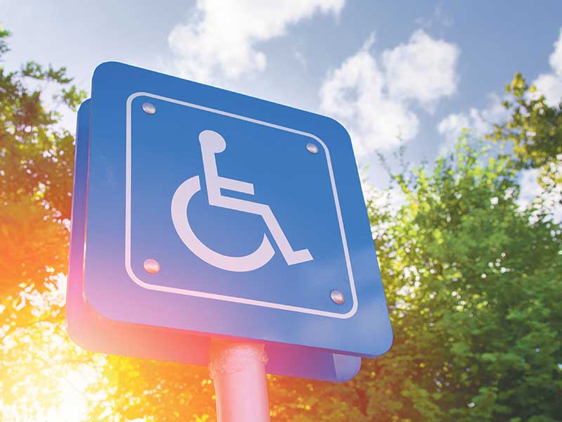 Disability sign, white wheelchair graphic on blue background