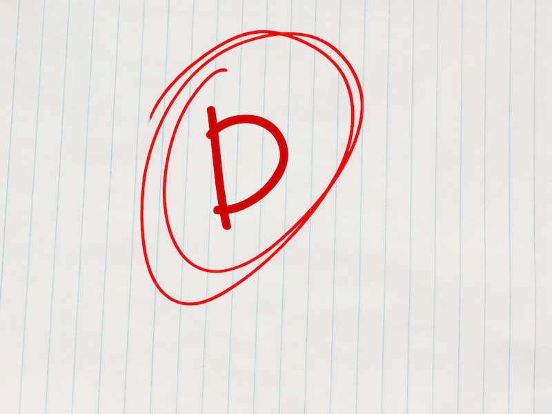 D grade written in red on notebook paper