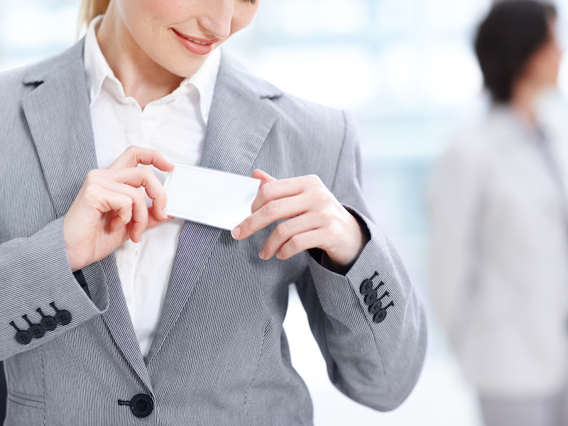 Cropped image of a smiling businesswoman pinning her name tag on her jacket - copyspace