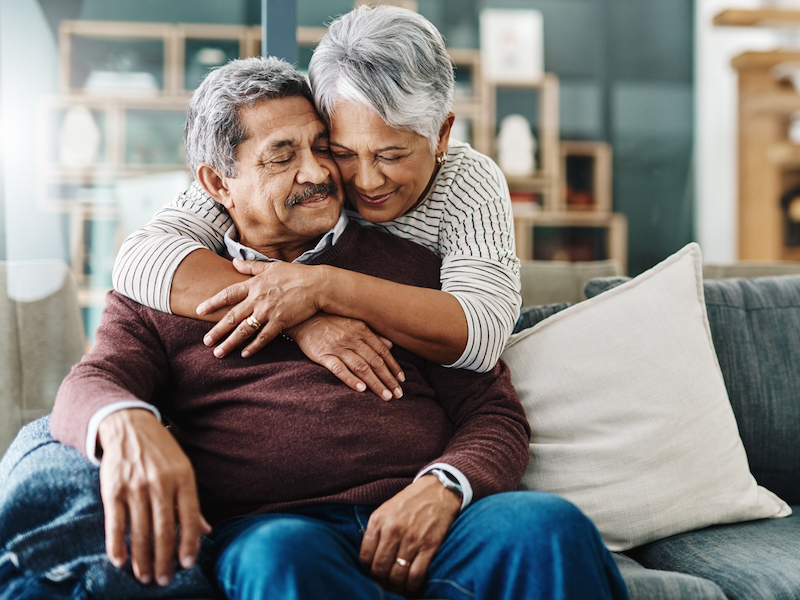 Cropped shot of a cheerful elderly woman hugging her husband who's in a wheelchair at home during the day