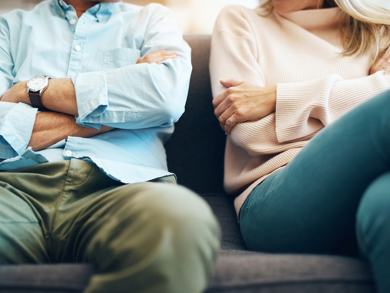 Cropped shot of an unrecognizable mature couple sitting on the sofa with their arms folded after an argument