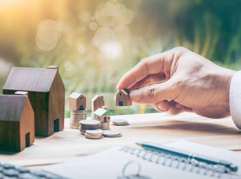 House placed on coins Men's hand is planning savings money of coins to buy a home concept concept for property ladder, mortgage and real estate investment. for saving or investment for a house,