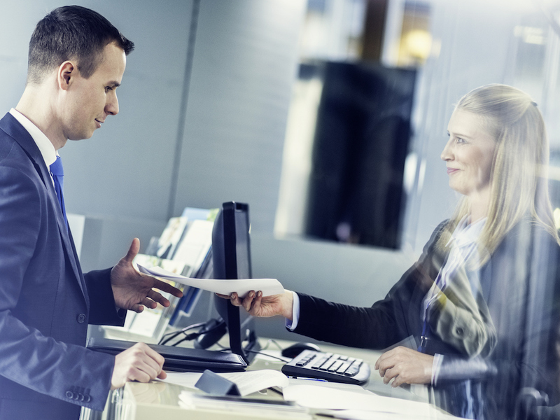 Businessman taking travel plan from a tourist agent at a tourist agency counter.