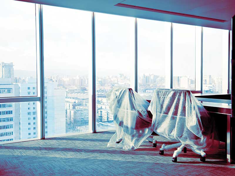 empty office chairs covered in bubble wrap