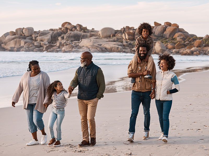 Shot of an adorable little boy and girl having a fun day at the beach with their parents and grandparents