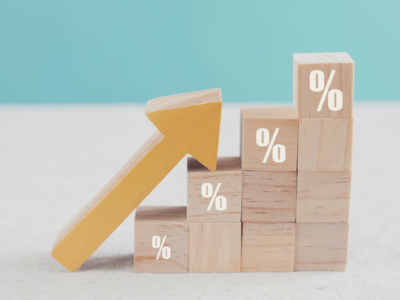 Wooden blocks with percentage sign and arrow up, financial growth, interest rate increase, inflation concept