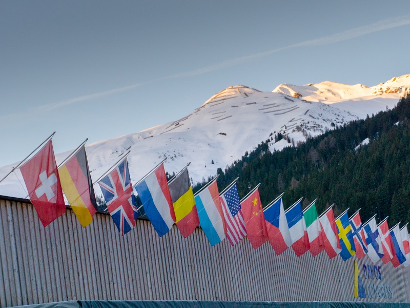 the congress center in Davos with flags of nations at sunrise during the WEF World Economic Forum