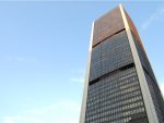 Montreal stock exchange tower against a clear blue sky.