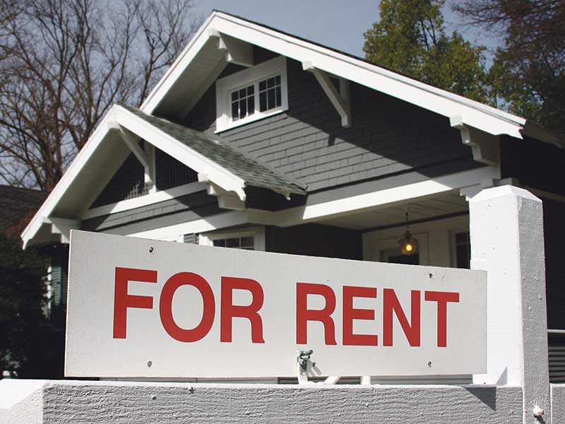 Photo of a "for rent" sign outside of a house