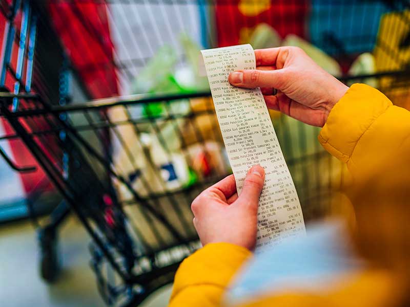 Person looking at grocery bill / concept of thrifty shopper