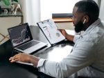 Successful crypto trader investor broker, using laptop for cryptocurrency financial market analysis, buying or selling cryptocurrency, analyzing financial diagrams on the screen stock photo
