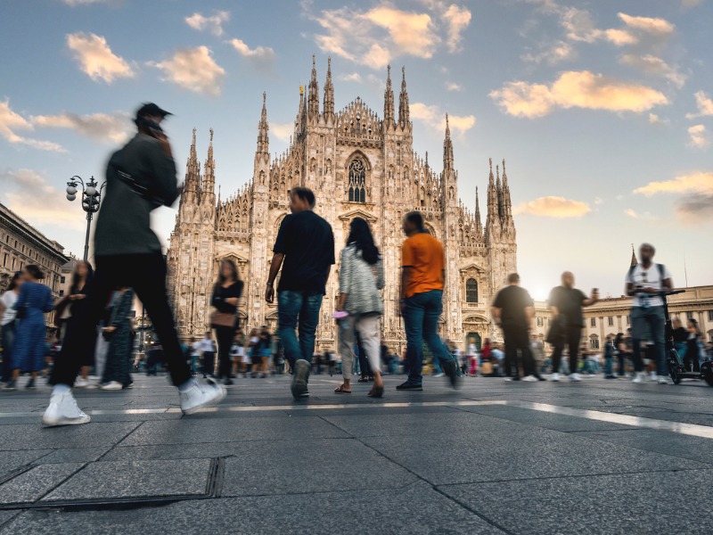 Blurred people, tourists and commuters at sunset crossing Duomo Square in Milano, Italy, Europe. i