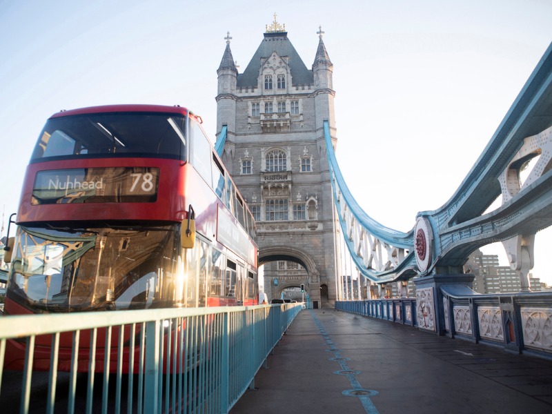 Red bus travelling over Tower Bridge stock photo