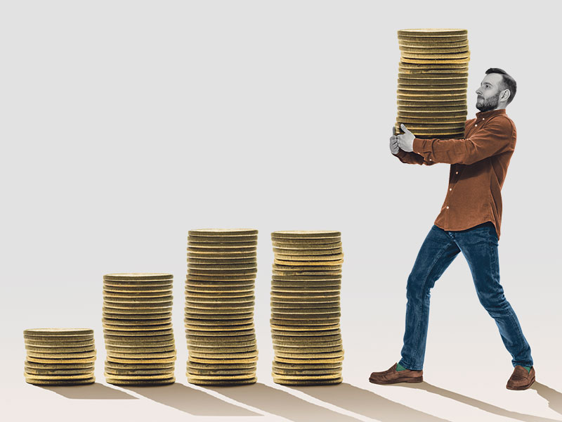 Man moving stack of coins to growing stack of coing. Concept of investment income growth.