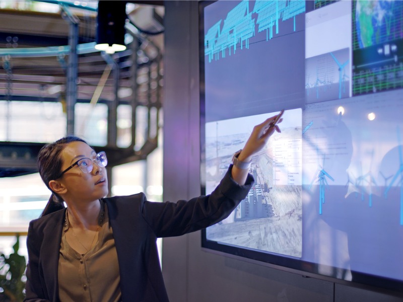 Woman giving a lecture on energy in front of a digital screen