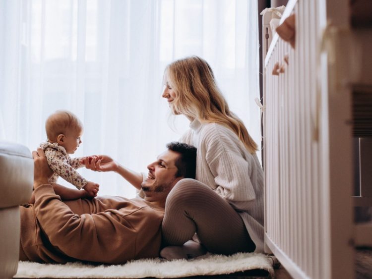 Cheerful parents playing with their baby at home