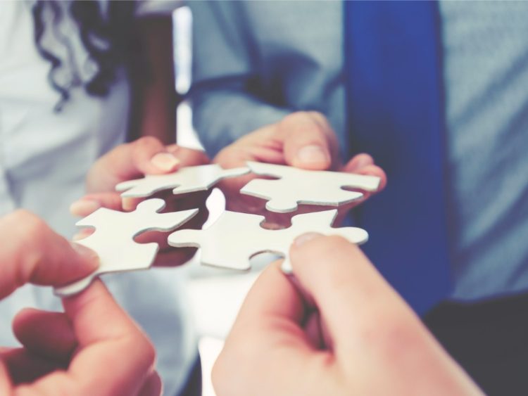 Group of businesspeople holding puzzle pieces