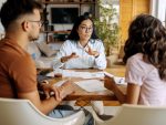 Young couple sitting at a table, getting advice from financial expert