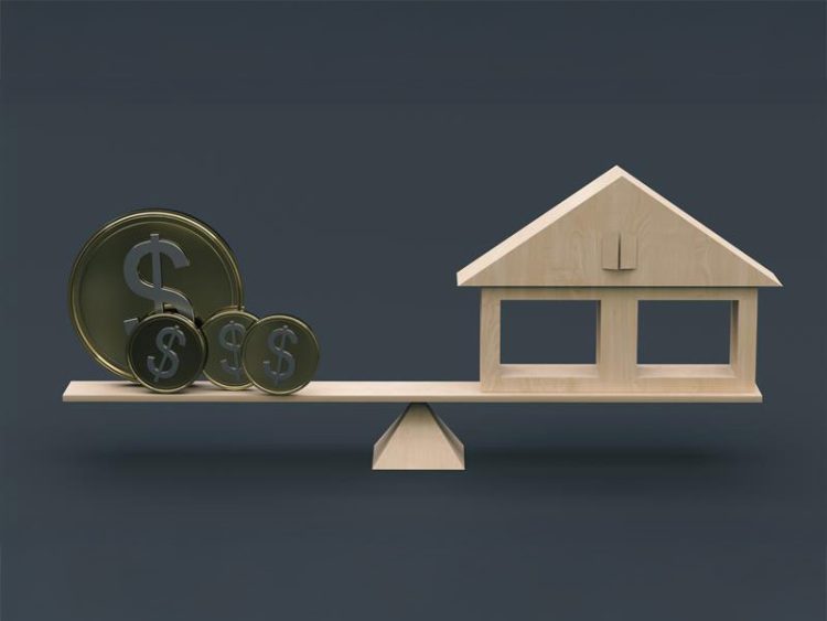 Stylized coins with a dollar symbol and a mock-up of a wooden house stand on a swing on a dark background.
